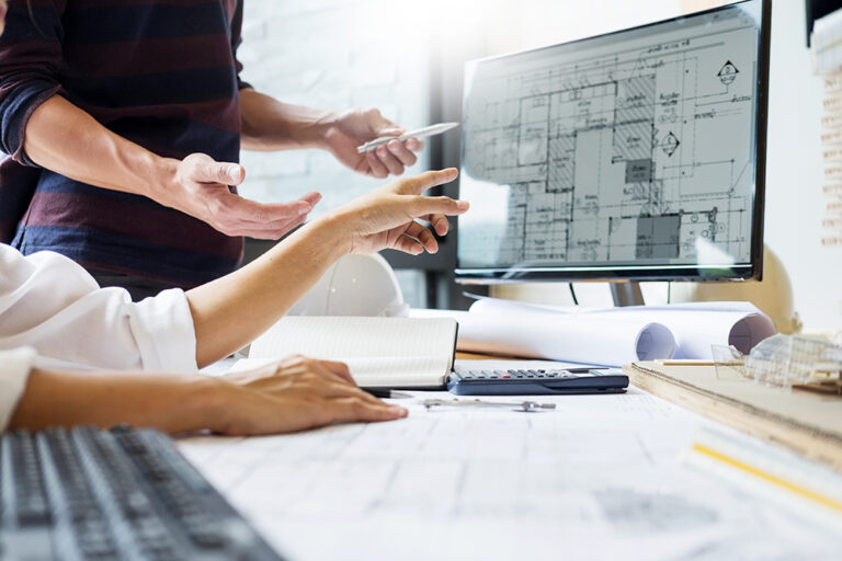 Architekten diskutieren vor einem PC Monitor mit einem Gebäudeplan