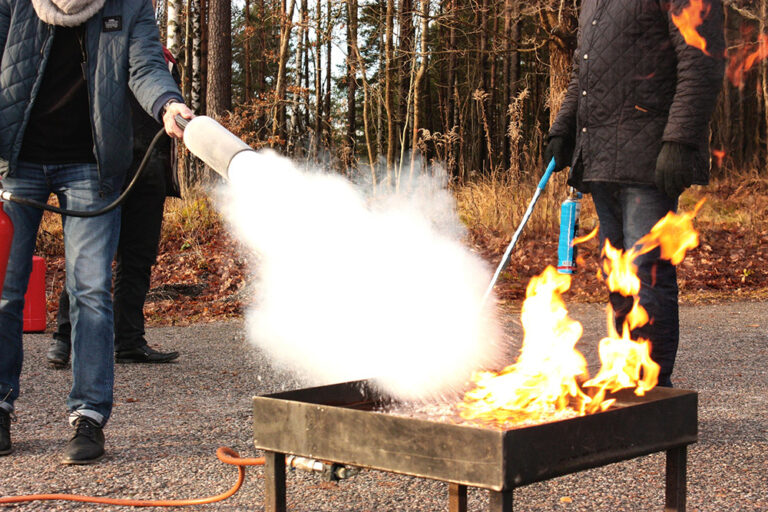 Zwei Menschen bei einer Brandschutzübung mit Feuerlöscher